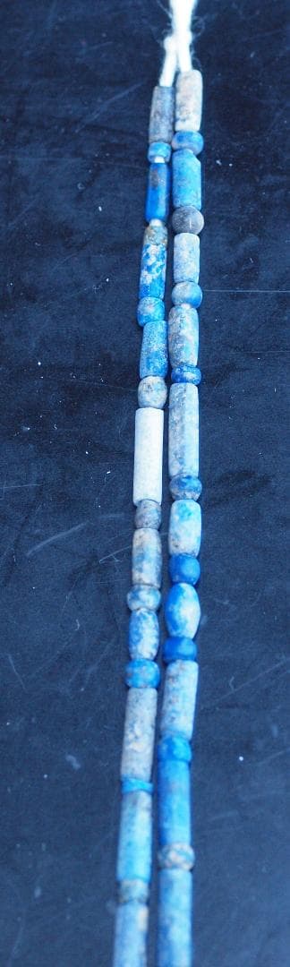 古代濃紺ラピスの管玉や丸玉をほぼ左右対称に編み、トップに斧型や多面体、80個の連